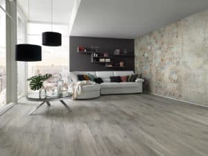 Sala con pavimento in laminato in colori tenui, con luce naturale, un divano e un tavolo con piante