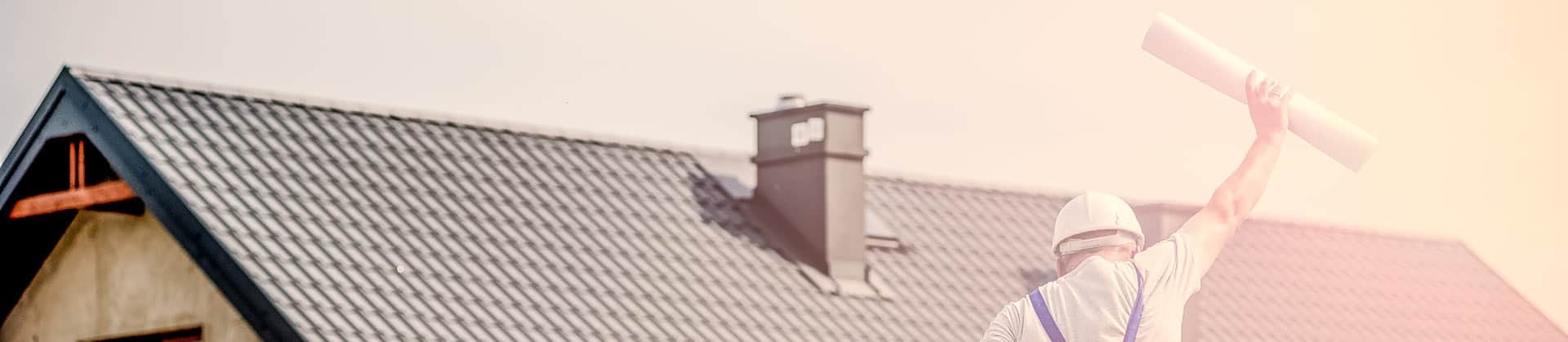 Tetto e di fronte un architetto che salta con un progetto arrotolato in mano